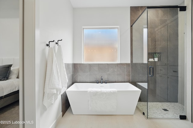 4614 138th Pl, Lubbock, TX 79424 - ensuite bathroom featuring a freestanding bath, a stall shower, and tile walls
