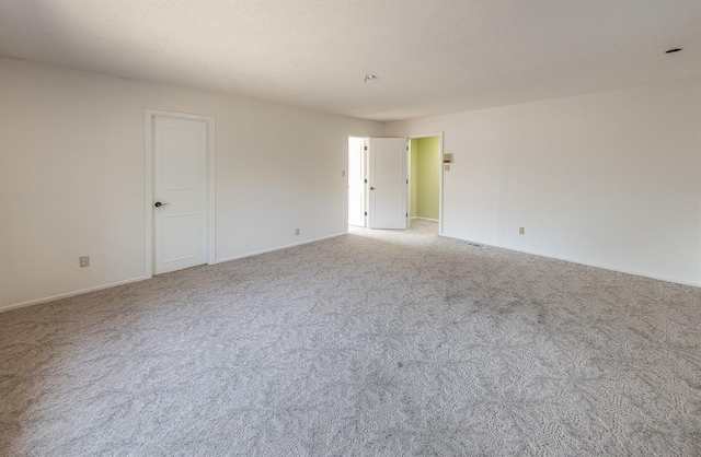 empty room featuring light colored carpet and a textured ceiling