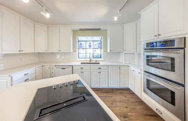 kitchen featuring double oven, white cabinetry, white dishwasher, and sink