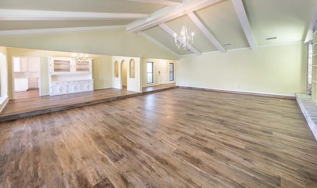 unfurnished living room featuring an inviting chandelier, high vaulted ceiling, beam ceiling, and dark wood-type flooring