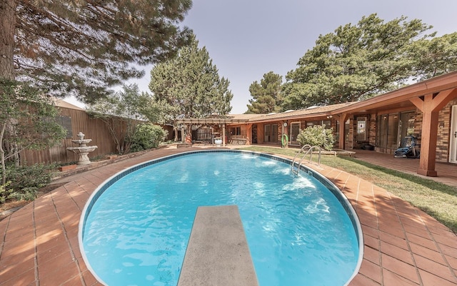 view of swimming pool with a patio and a diving board