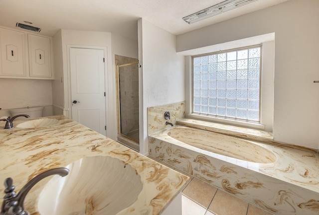 bathroom with tile patterned floors, shower with separate bathtub, vanity, and a textured ceiling