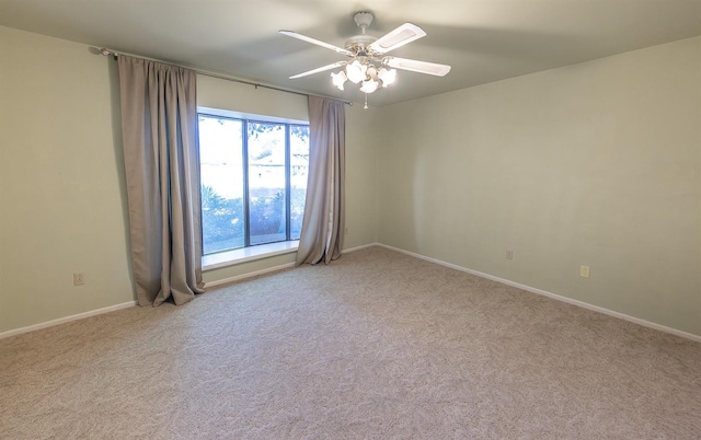 carpeted spare room featuring ceiling fan