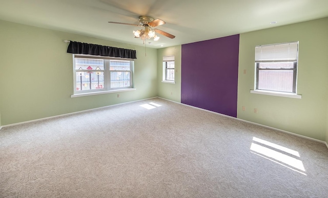 carpeted spare room with ceiling fan