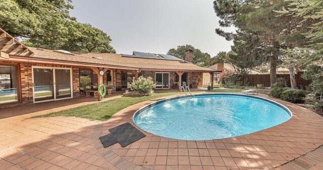 view of pool with a patio and a diving board