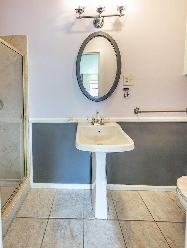 bathroom with walk in shower, toilet, and tile patterned flooring