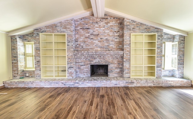 unfurnished living room featuring vaulted ceiling with beams, hardwood / wood-style floors, built in features, and a fireplace