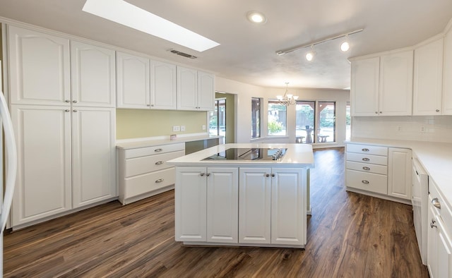 kitchen with pendant lighting, dark hardwood / wood-style flooring, white cabinetry, a kitchen island, and black electric cooktop