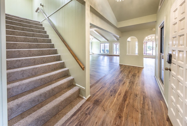 foyer featuring lofted ceiling, a notable chandelier, and dark hardwood / wood-style flooring