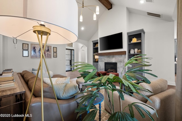 4606 138th Pl, Lubbock, TX 79424 - living room featuring beam ceiling, a fireplace, arched walkways, wood finished floors, and high vaulted ceiling