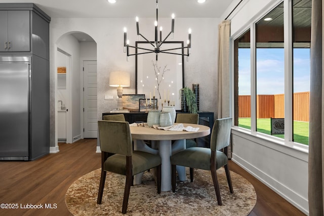 4606 138th Pl, Lubbock, TX 79424 - dining space featuring arched walkways, dark wood-style flooring, and a chandelier