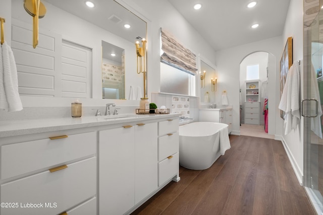 4606 138th Pl, Lubbock, TX 79424 - bathroom with vanity, a stall shower, a freestanding bath, wood finished floors, and recessed lighting