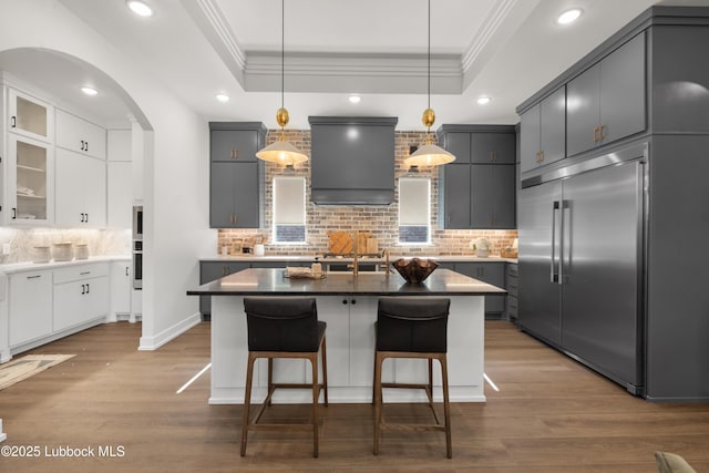 4606 138th Pl, Lubbock, TX 79424 - kitchen with stainless steel built in refrigerator, ornamental molding, a tray ceiling, extractor fan, and tasteful backsplash