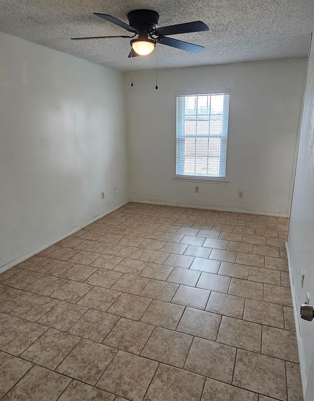 tiled empty room featuring ceiling fan and a textured ceiling