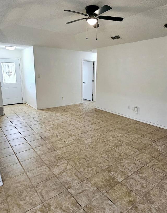 unfurnished room with ceiling fan and a textured ceiling