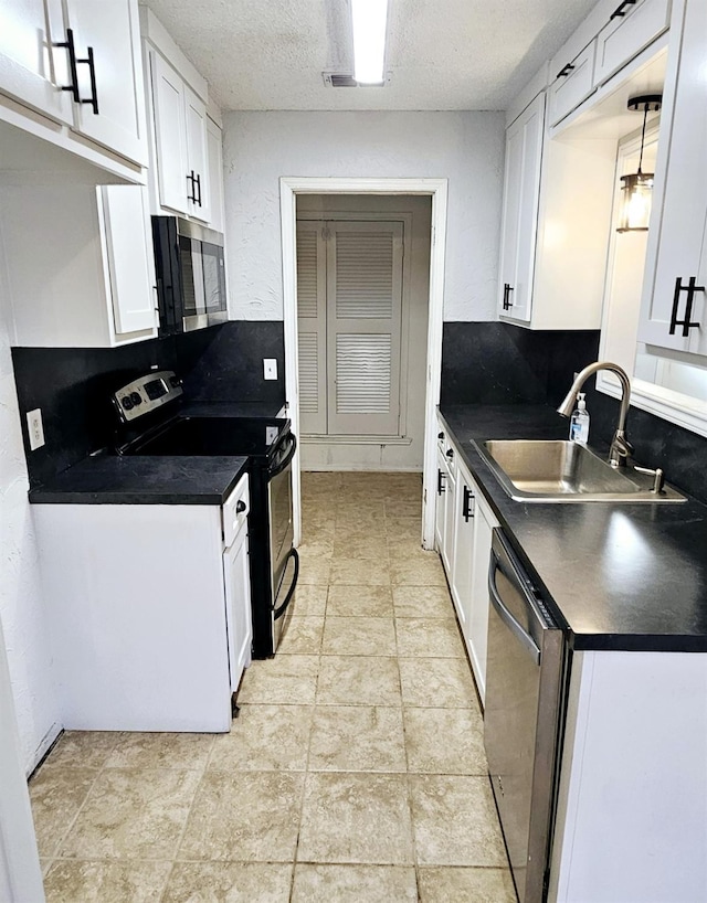 kitchen featuring sink, white cabinetry, tasteful backsplash, a textured ceiling, and appliances with stainless steel finishes