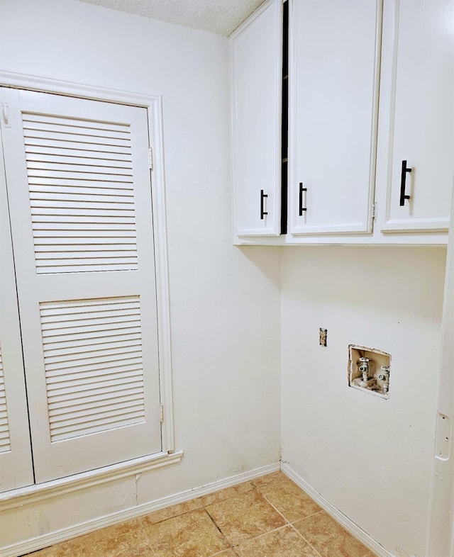 laundry area featuring hookup for a washing machine, cabinets, and light tile patterned flooring