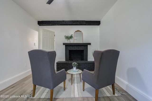 3819 30th St, Lubbock, TX 79410 - living area with beamed ceiling, baseboards, wood finished floors, and a brick fireplace
