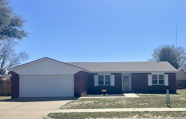 ranch-style home featuring a garage, driveway, brick siding, and fence