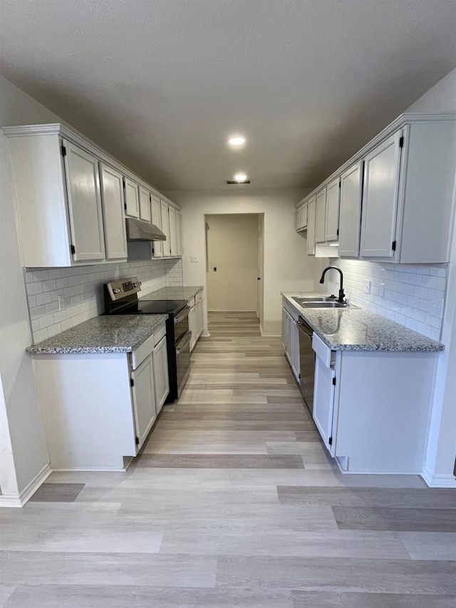 kitchen featuring white cabinetry, stainless steel appliances, light stone countertops, and sink