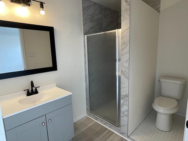 bathroom with vanity, hardwood / wood-style floors, a shower with shower door, and toilet