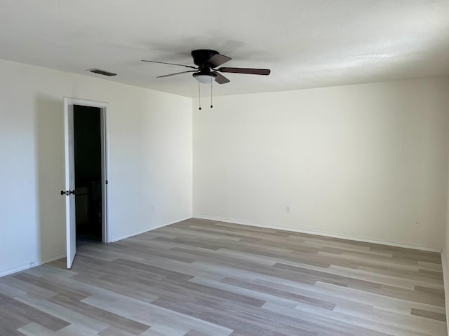 spare room with ceiling fan and light wood-type flooring