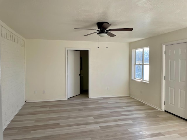 unfurnished room featuring ceiling fan, a textured ceiling, and light wood-type flooring