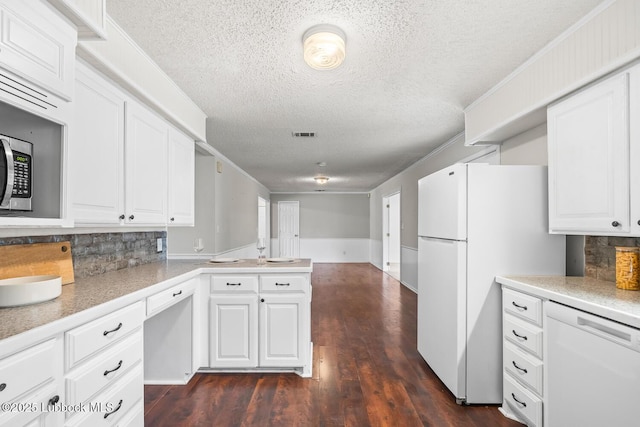 3415 39th St, Lubbock, TX 79413 - kitchen featuring white appliances, a textured ceiling, a peninsula, decorative backsplash, and white cabinetry