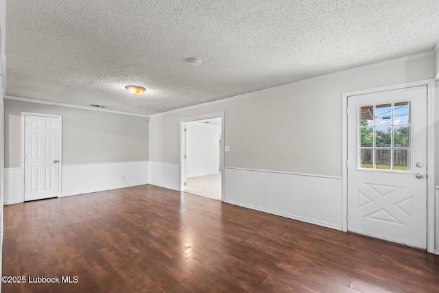 3415 39th St, Lubbock, TX 79413 - unfurnished room featuring ornamental molding, a textured ceiling, a wainscoted wall, and wood finished floors