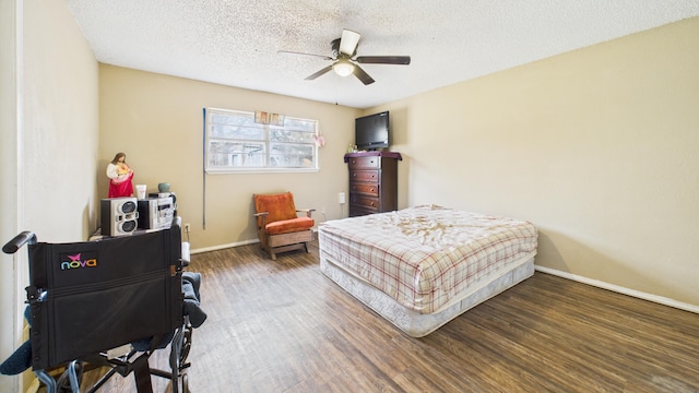 bedroom featuring baseboards, wood finished floors, a ceiling fan, and a textured ceiling