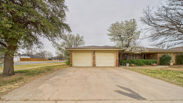 exterior space featuring concrete driveway, an attached garage, and brick siding
