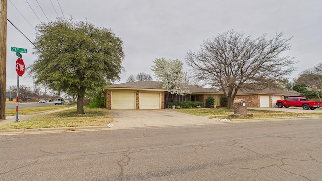 single story home with a garage, brick siding, and concrete driveway