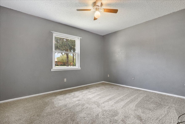 carpeted spare room with a textured ceiling and ceiling fan