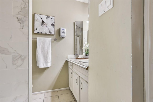 bathroom with vanity, tile patterned flooring, and a tile shower