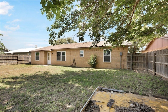 back of house featuring a lawn