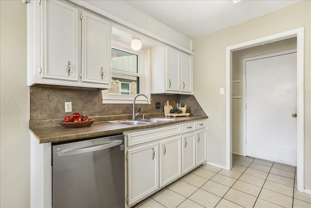 kitchen with sink, light tile patterned floors, a textured ceiling, white cabinets, and stainless steel dishwasher