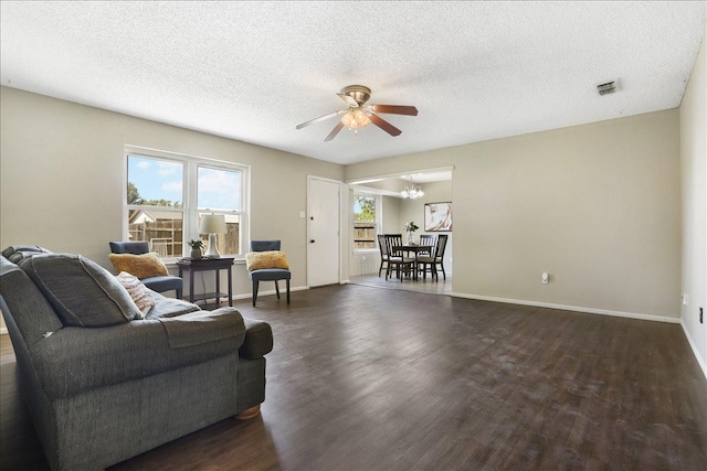 living room with ceiling fan, dark hardwood / wood-style floors, and a textured ceiling