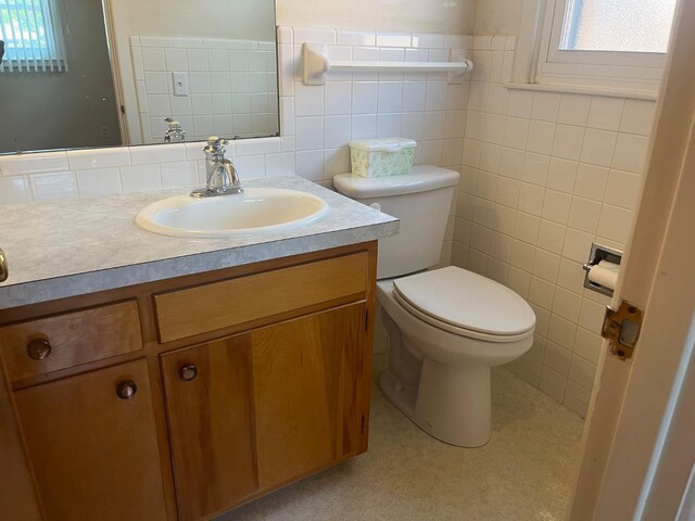 bathroom featuring tile walls, vanity, and toilet