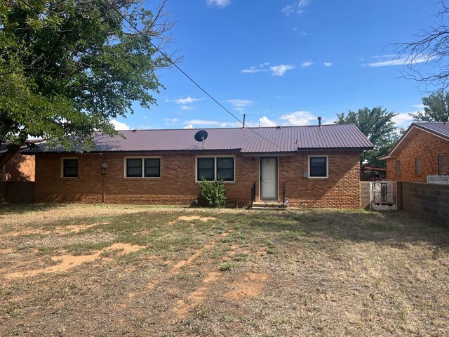 rear view of house featuring a lawn