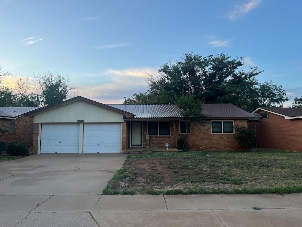 ranch-style house with a yard and a garage