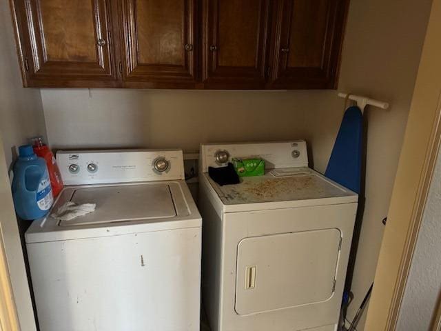 laundry area with washing machine and dryer and cabinets