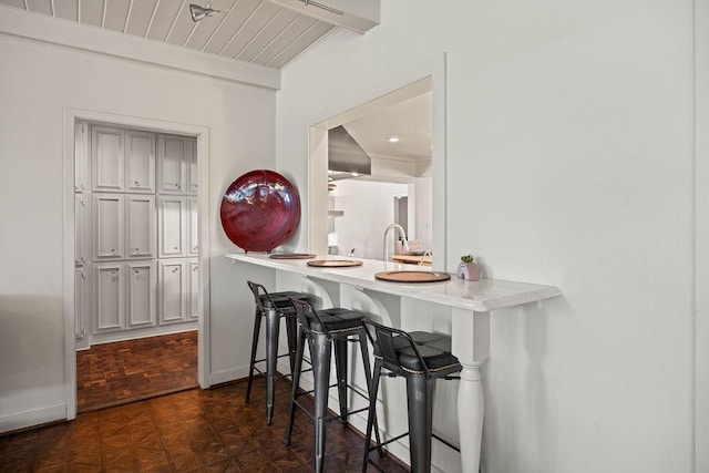 bar featuring sink, crown molding, dark parquet floors, and beamed ceiling