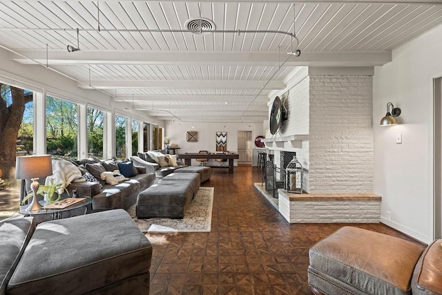 living room featuring a brick fireplace and beam ceiling