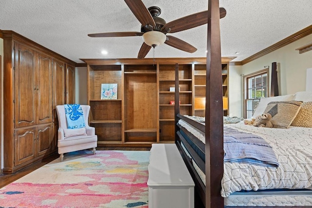 bedroom featuring crown molding, dark hardwood / wood-style flooring, a textured ceiling, and ceiling fan