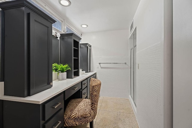 bathroom with vanity and a shower with door