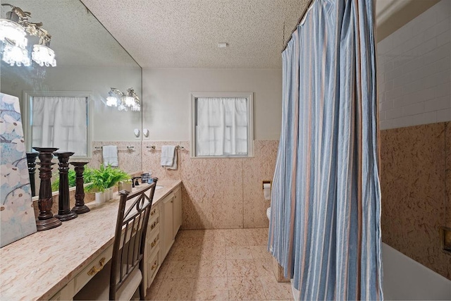 bathroom featuring vanity, tile walls, a textured ceiling, and toilet