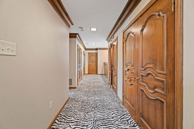 corridor featuring light colored carpet and ornamental molding