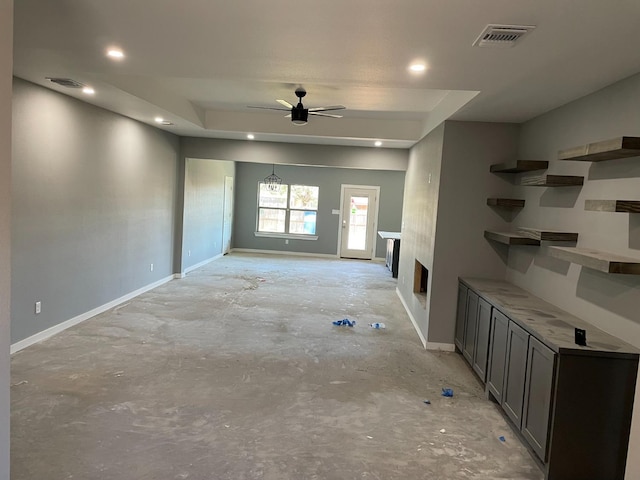 unfurnished living room with ceiling fan with notable chandelier