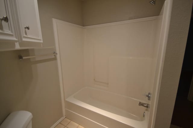 bathroom with shower / washtub combination, toilet, and tile patterned flooring