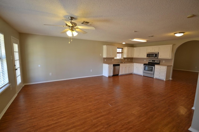 unfurnished living room featuring ceiling fan, sink, a textured ceiling, and dark hardwood / wood-style flooring